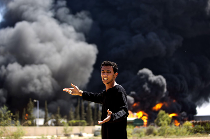 A Palestinian man reacts as flames engulf the fuel tanks of the only power plant supplying electricity to the Gaza Strip after it was hit by overnight Israeli shelling, on July 29, 2014, in the south of Gaza City. The damage of the power plant exacerbated the heavy damage to civilian infrastructure in Gaza already inflicted during the 22 days of the Israeli offensive aimed at stamping out militant rocket fire and destroying attack tunnels. AFP PHOTO/MAHMUD HAMSMAHMUD HAMS/AFP/Getty Images