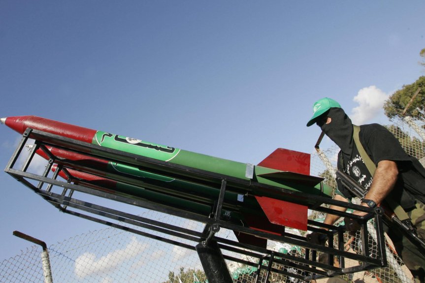 GAZA CITY:  A Palestinian militant from the Ezzedine al-Qassam Brigades, the military wing of the Islamic Resistance Movement Hamas, displays Qassam rockets during a rally in Gaza City 18 September 2005. (ABED/AFP/Getty Images)