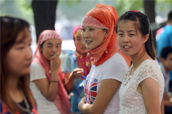 Female Muslims smile wearing hijabs as they attend a festival at Niujie Mosque in Beijing on Aug 8, 2013, part of activities to celebrate Eid Al-Fitr marking the end of Islam’s fasting month of Ramadan. [Zou Hong/Asianewsphoto]