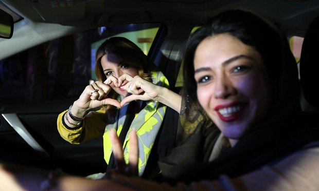 Iranian women flash a heart sign during celebration in northern Tehran on 14 July 2015.